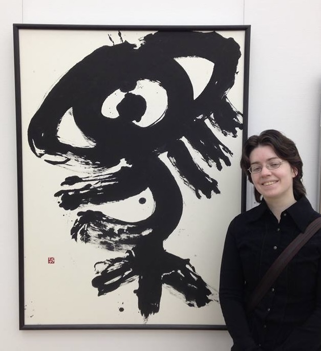 Me standing in front of my artwork on display at an exhibition.