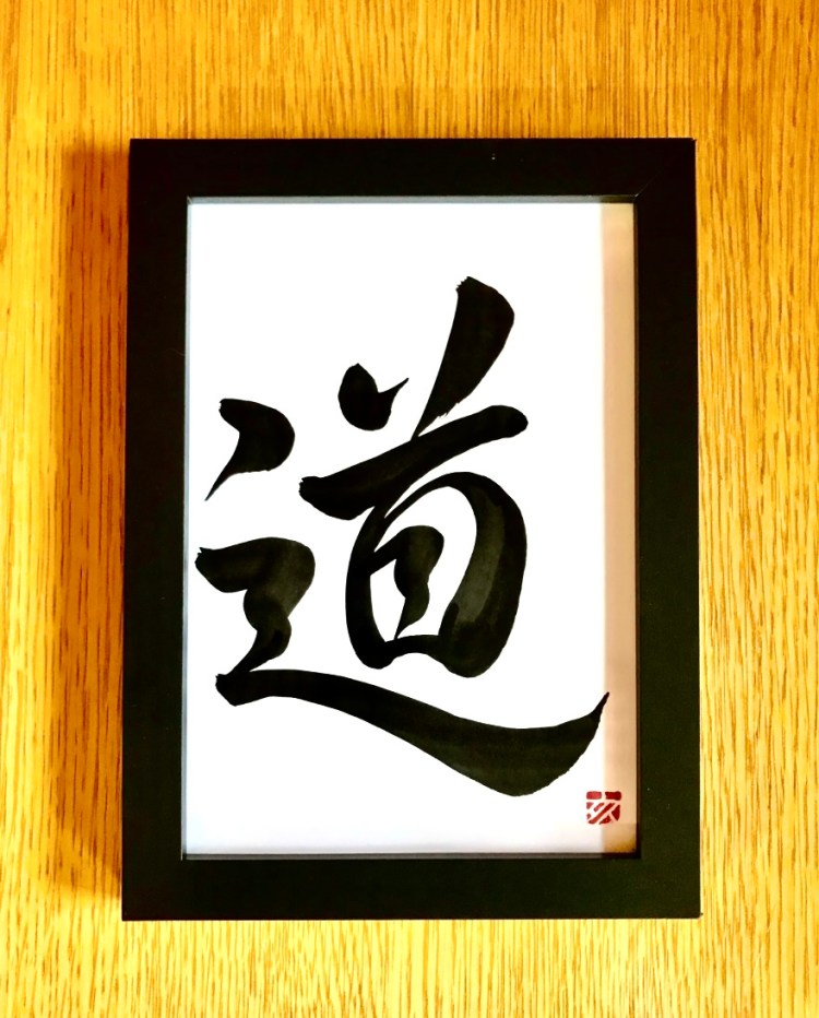 A Japanese calligraphy artwork of 1 character, black ink on white paper. It means "the way", or "the tao".