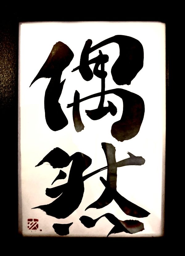 A Japanese calligraphy artwork. The writing means "coincidence".