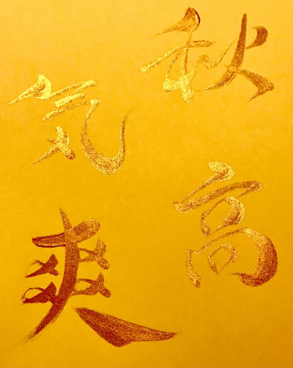 A Japanese calligraphy work of 4 kanji characters, gold ink on orange card.