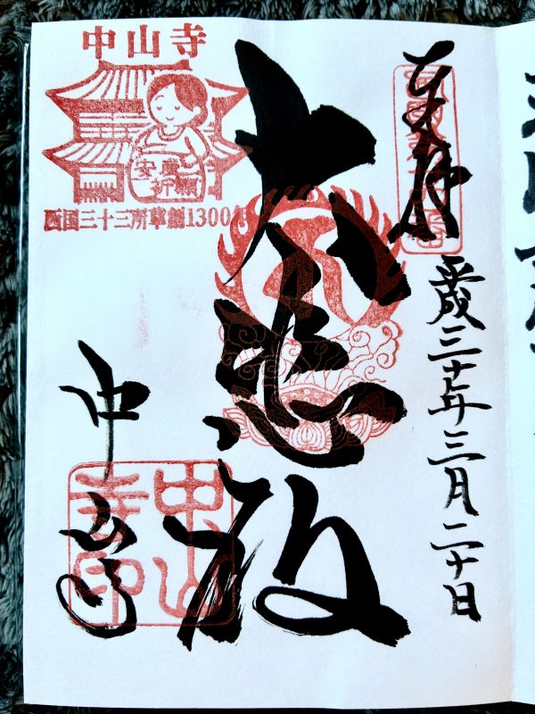 The inside of a commemorative stamp book, a white page covered in black calligraphy and red ink stamps.