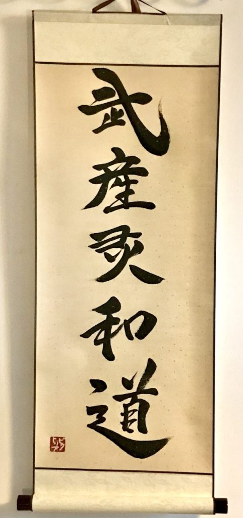 A Japanese calligraphy on a hanging scroll. The work has 5 kanji characters, in black ink.